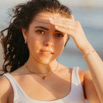 Woman shielding her eyes from the sun with a blurred natural background