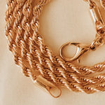 gold rope chain necklace on a beige background
