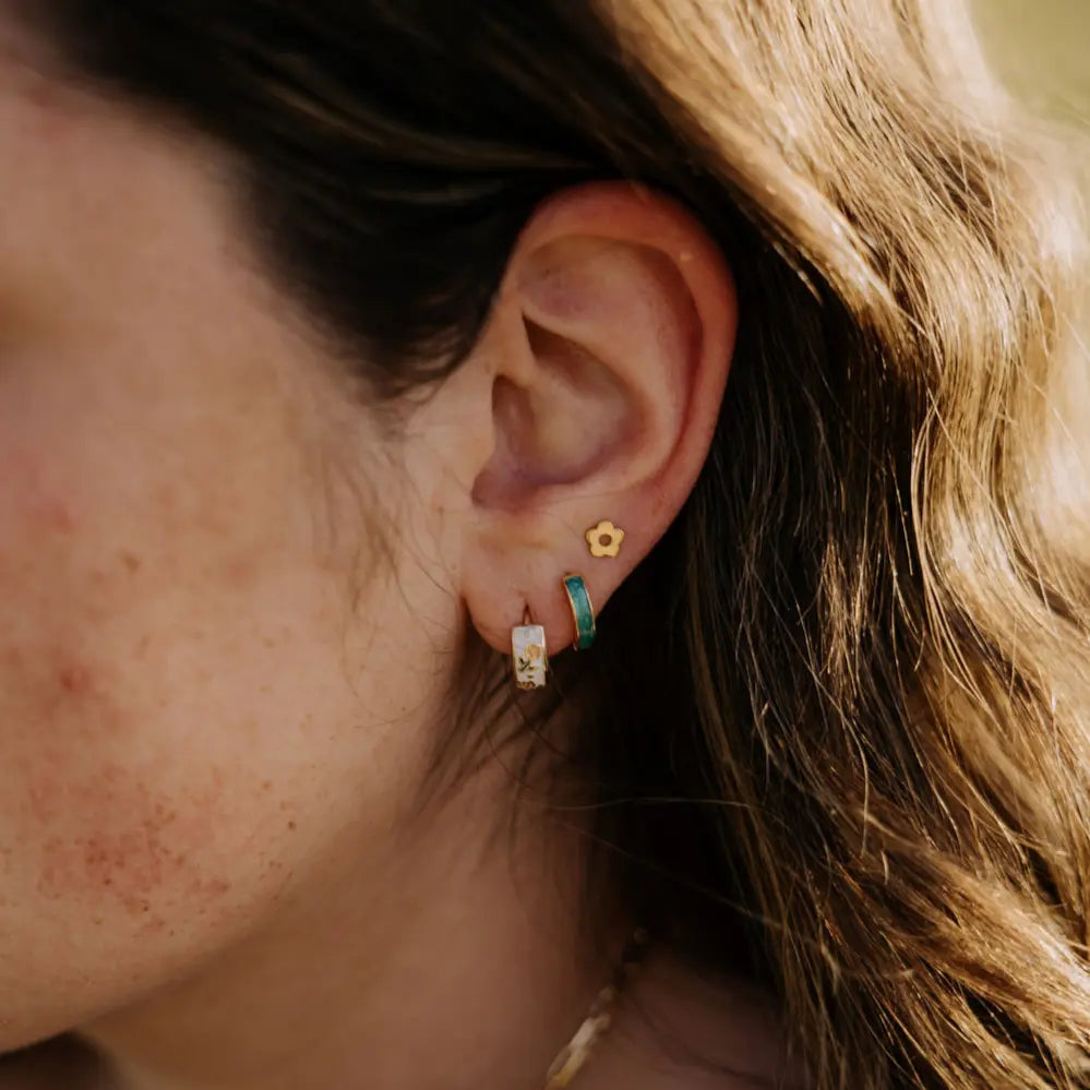 Close-up of an ear with multiple earrings on a blurred background