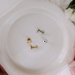 Three small metal objects on a white plate