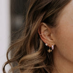 Close-up of an ear with multiple earrings and a blurred background