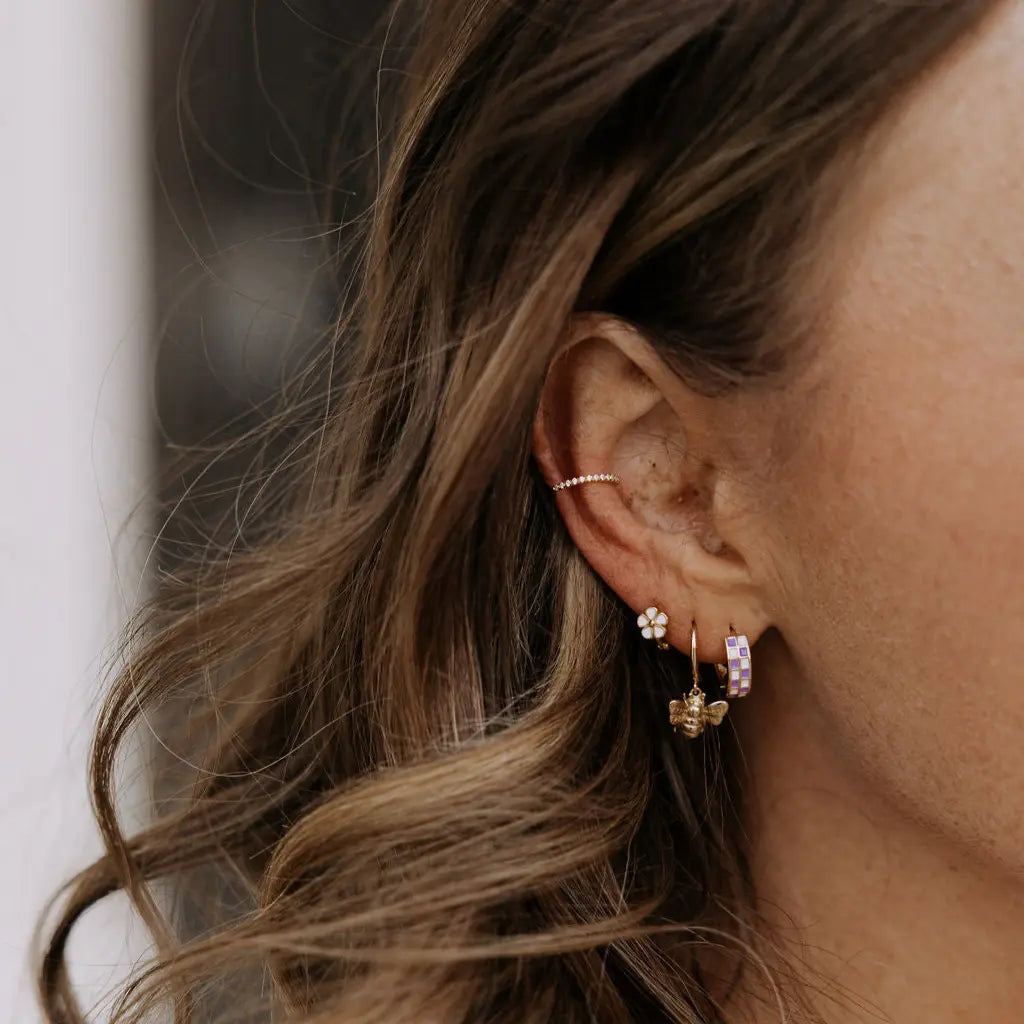 Close-up of an ear with multiple earrings and a blurred background
