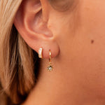 Load image into Gallery viewer, Close-up of an ear wearing gold hoop earrings with sun detail.
