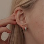 Load image into Gallery viewer, Close-up of an ear with small star earrings and a hand adjusting hair.
