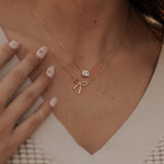 Necklace with a bow and gemstone pendant worn by a person