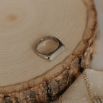 Silver ring on a wooden surface