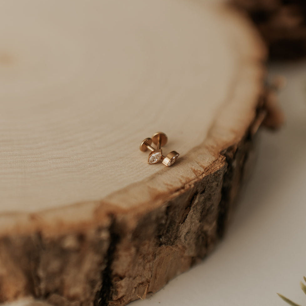 Gold earrings on a wooden surface with a blurred background