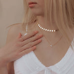 Load image into Gallery viewer, Woman wearing a white top with delicate necklaces against a neutral background
