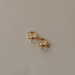 Pair of gold earrings on a beige background