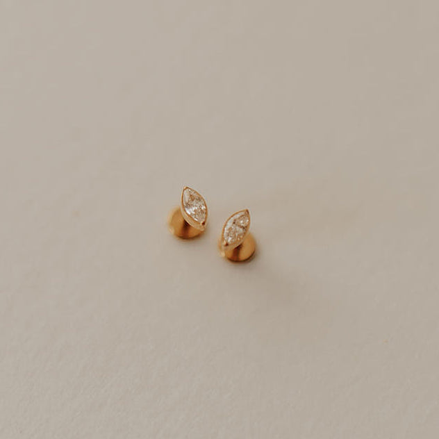 Pair of gold earrings on a beige background