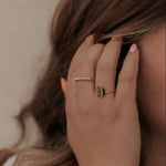Load image into Gallery viewer, Close-up of a hand with gold rings and a bracelet, holding hair against a neutral background

