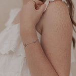 Person wearing a delicate bracelet with a blurred background