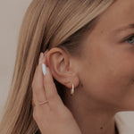 Load image into Gallery viewer, Woman wearing gold earrings and a bracelet, with a neutral background
