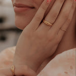 Load image into Gallery viewer, Close-up of a person's hands with gold rings on a blurred background
