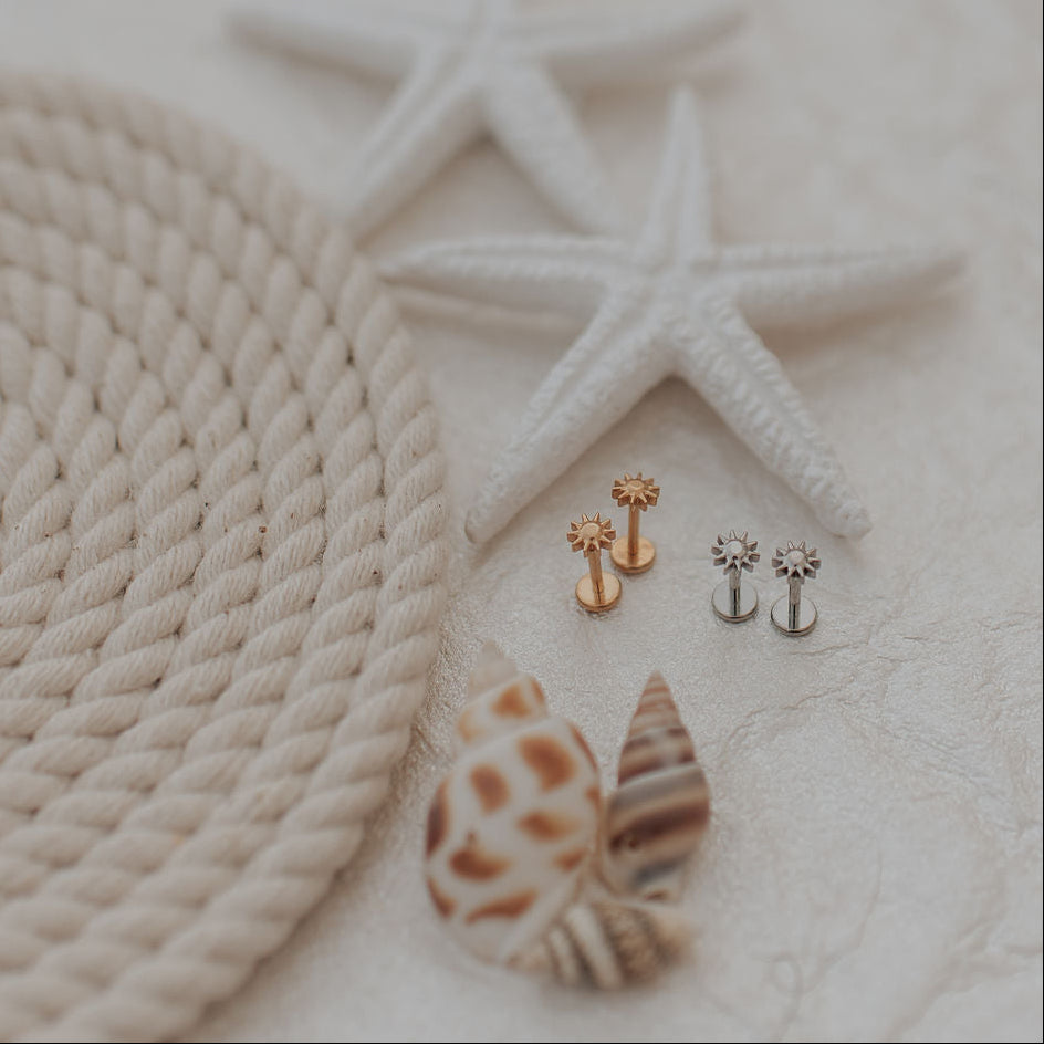 Sun earrings on a textured surface