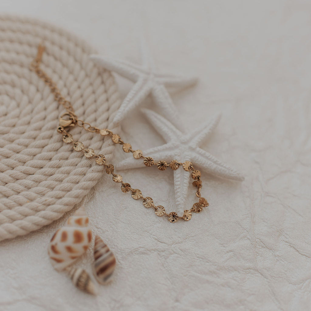 bracelet with a shell pendant on a textured surface