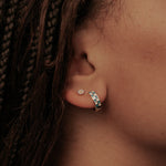 Load image into Gallery viewer, Close-up of an ear with daisy flat back earrings and blue and white checkered hoops and braided hair
