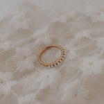 Load image into Gallery viewer, Gold ring with small pearls on a textured beige fabric background
