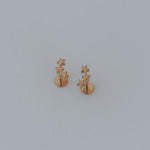 Load image into Gallery viewer, Pair of gold star earrings on a light gray background
