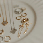 Collection of gold and silver jewelry on a textured surface