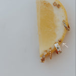 Gold earrings on a lemon