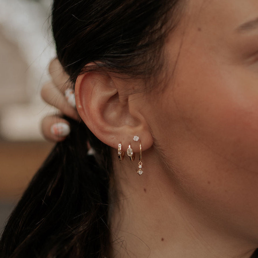 Close-up of a person wearing earrings with a blurred background