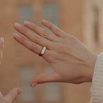 Close-up of two hands with a ring, blurred background