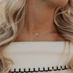 Close-up of a person wearing a delicate necklace with a small pendant.