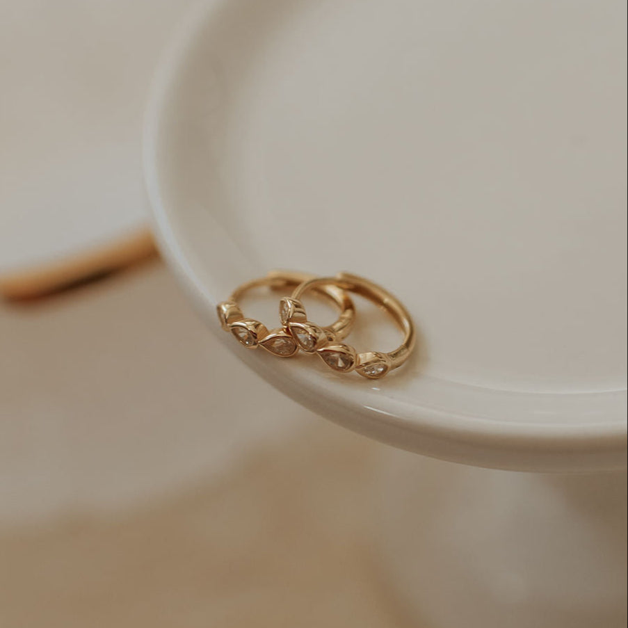 Two gold rings on a white dish with a blurred background