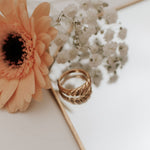 Load image into Gallery viewer, Gold ring on a white surface with a peach-colored flower and small white flowers.
