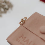 Close-up of a pink leather pouch with 'MAUVE' branding on a light background.