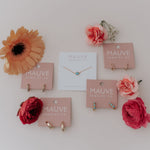 Jewelry display with necklaces on pink cards against a white background