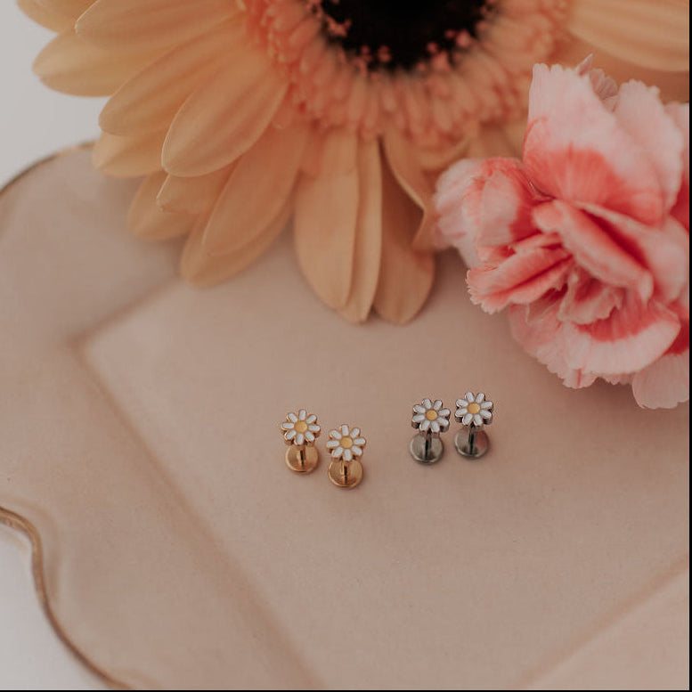 Pair of earrings on a decorative plate with flowers