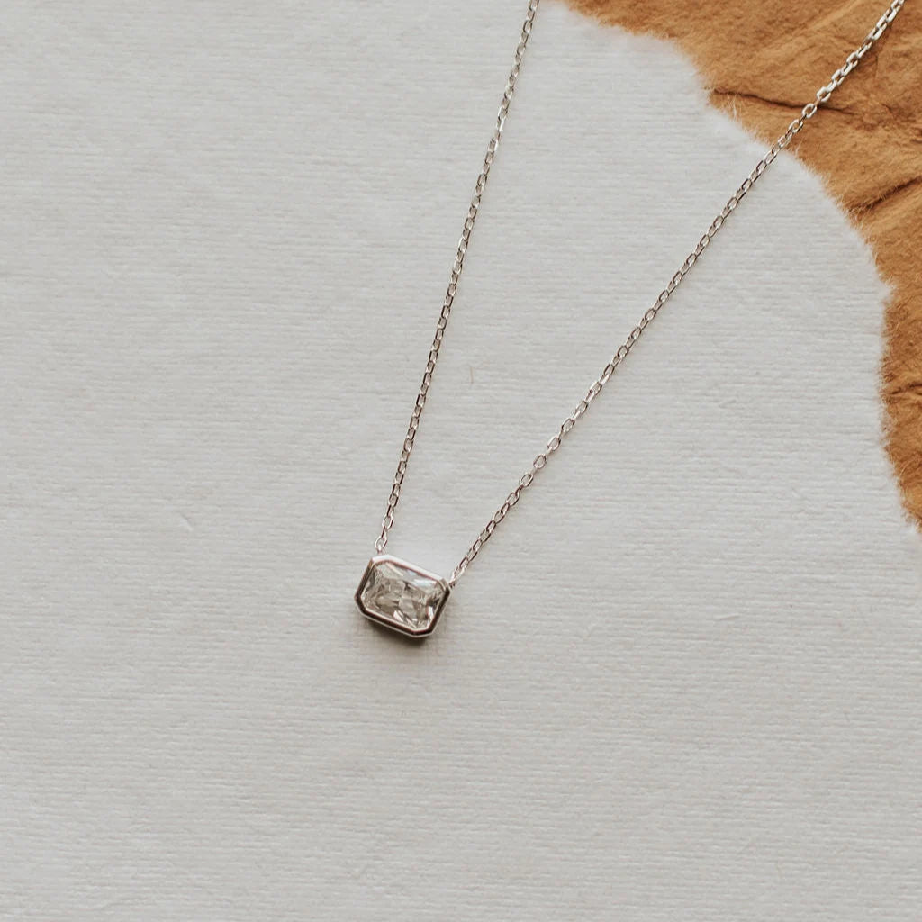 Silver necklace with a pendant on a textured surface