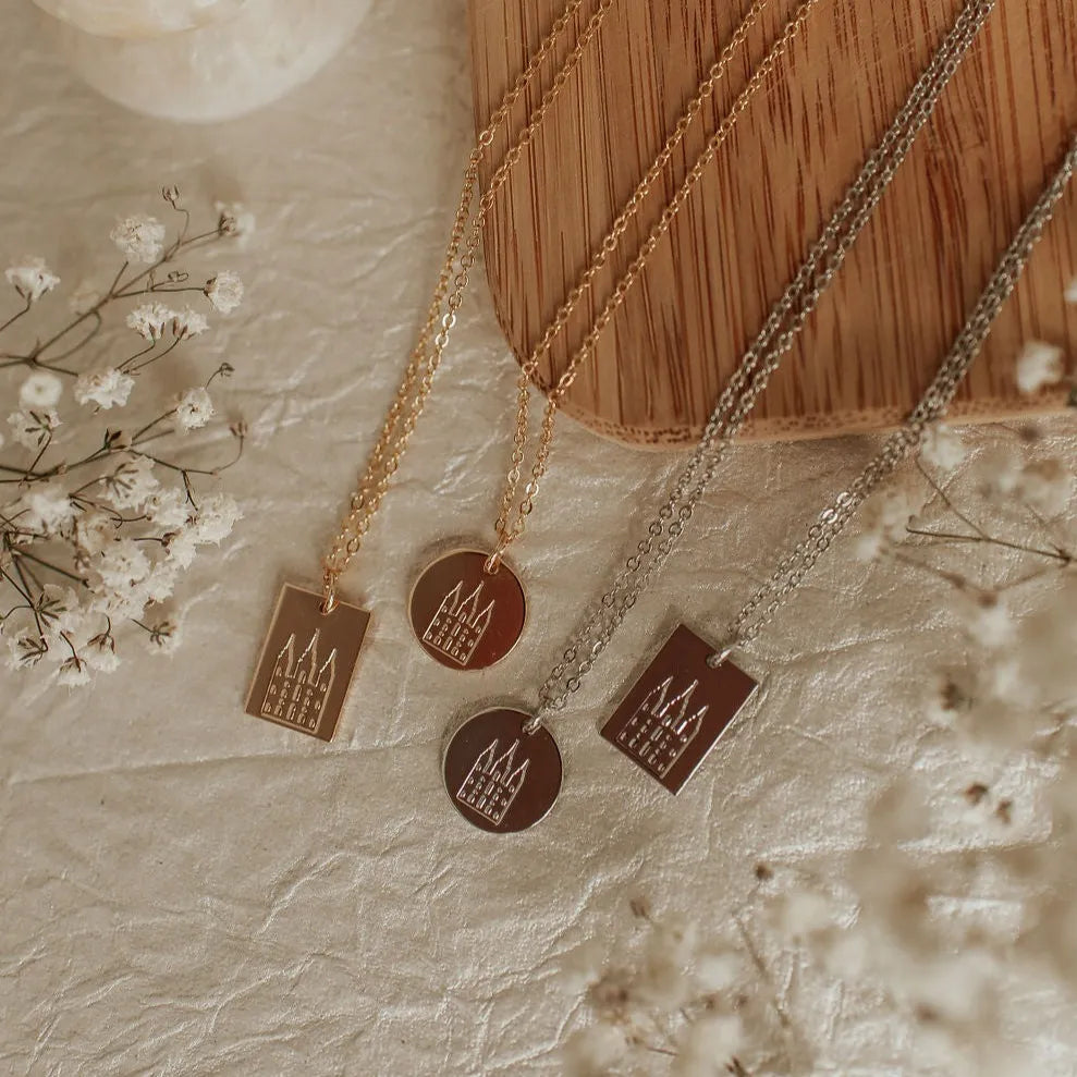Necklaces with pendant tags on a textured surface with flowers
