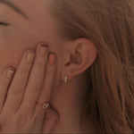 Load image into Gallery viewer, Close-up of a person wearing gold earrings and rings with a blurred background

