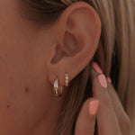 Load image into Gallery viewer, Close-up of an ear with gold star hoop earrings and a hand touching the earlobe.
