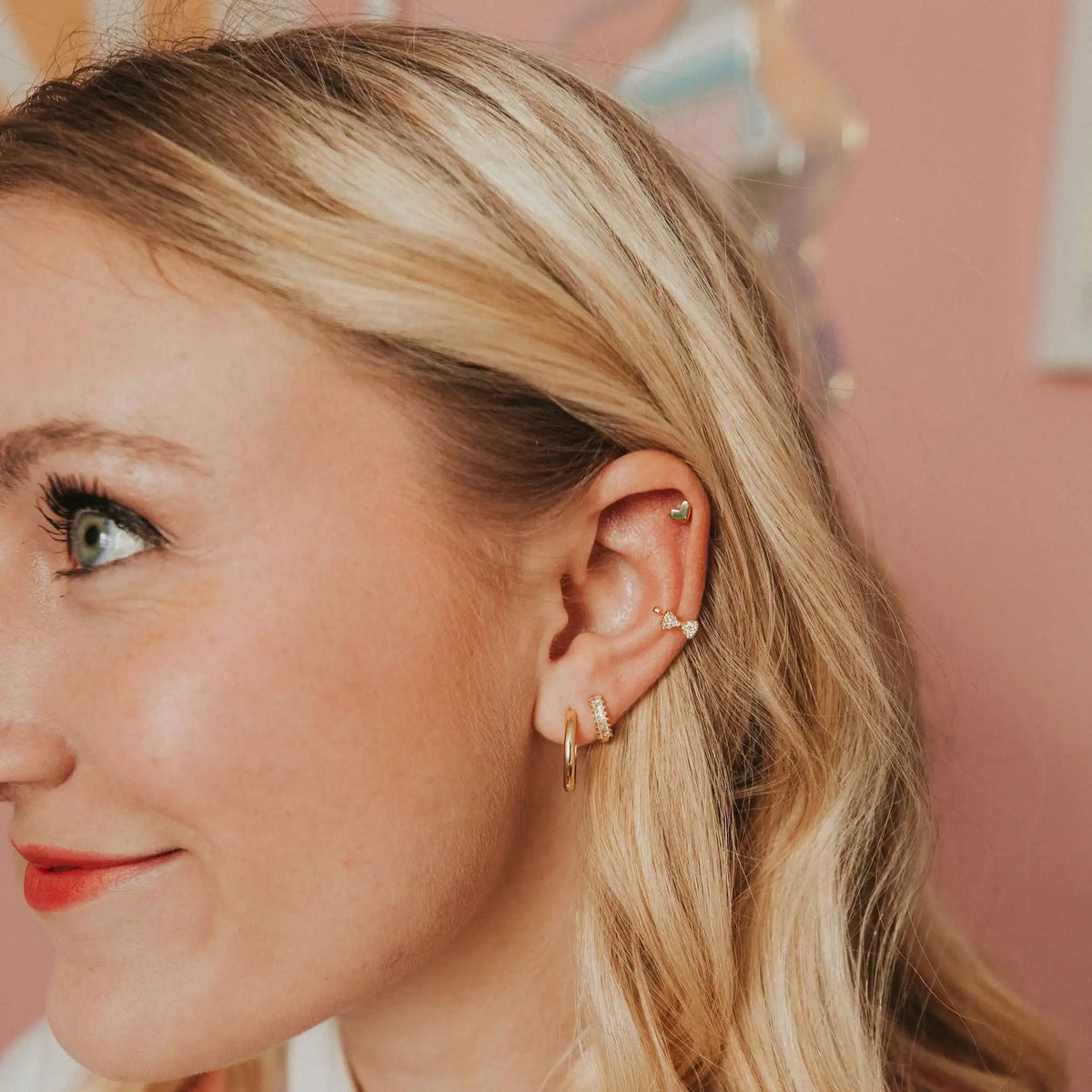 Close-up of a woman wearing gold earrings with a blurred background