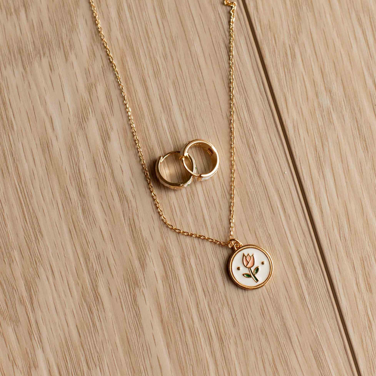 Gold necklace with circular pendants on a wooden surface
