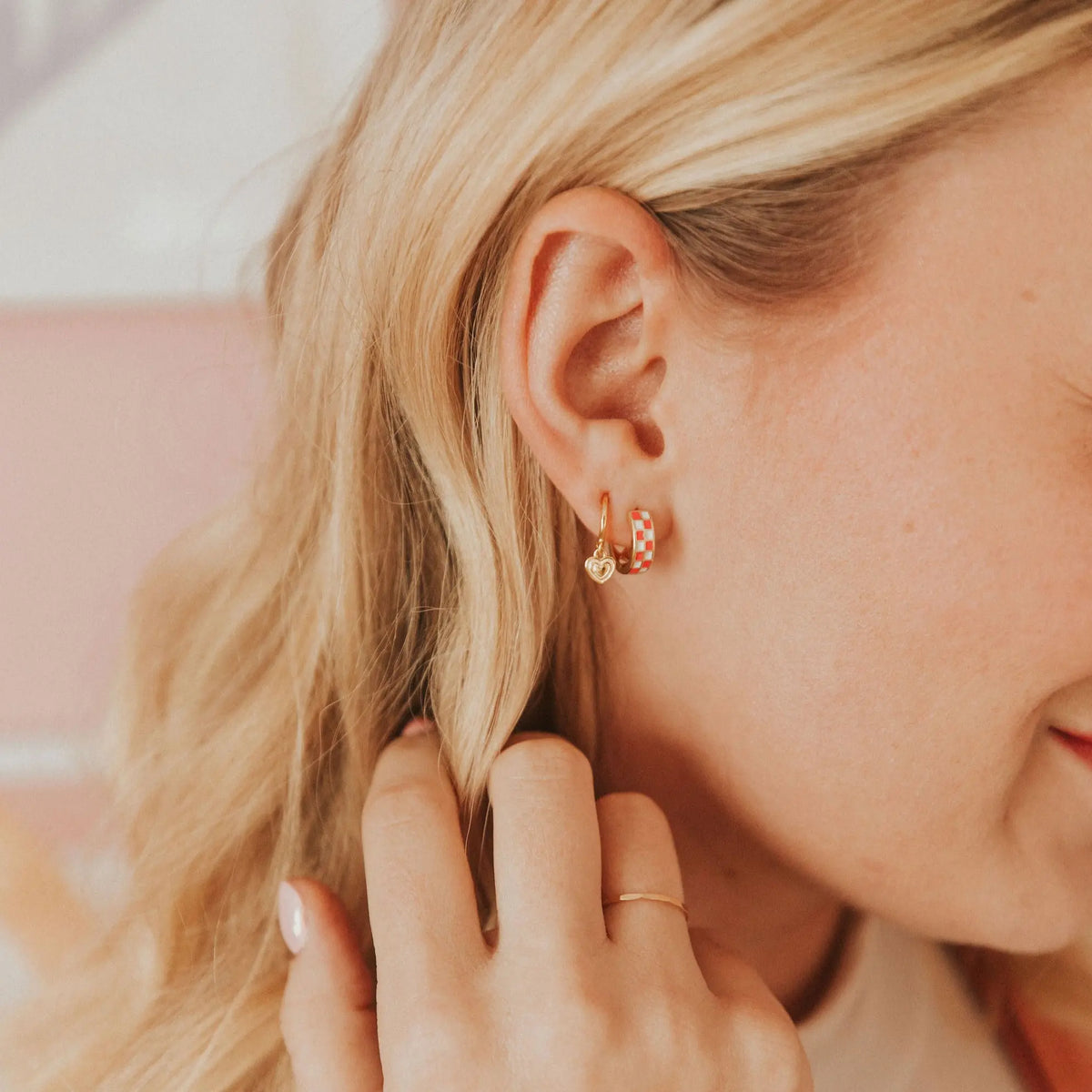 Close-up of a person wearing checkered earrings with a blurred background