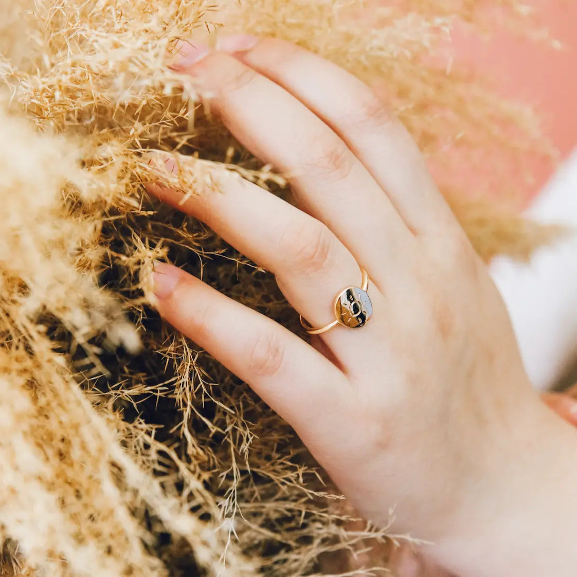 Hand with a gold ring on a textured surface