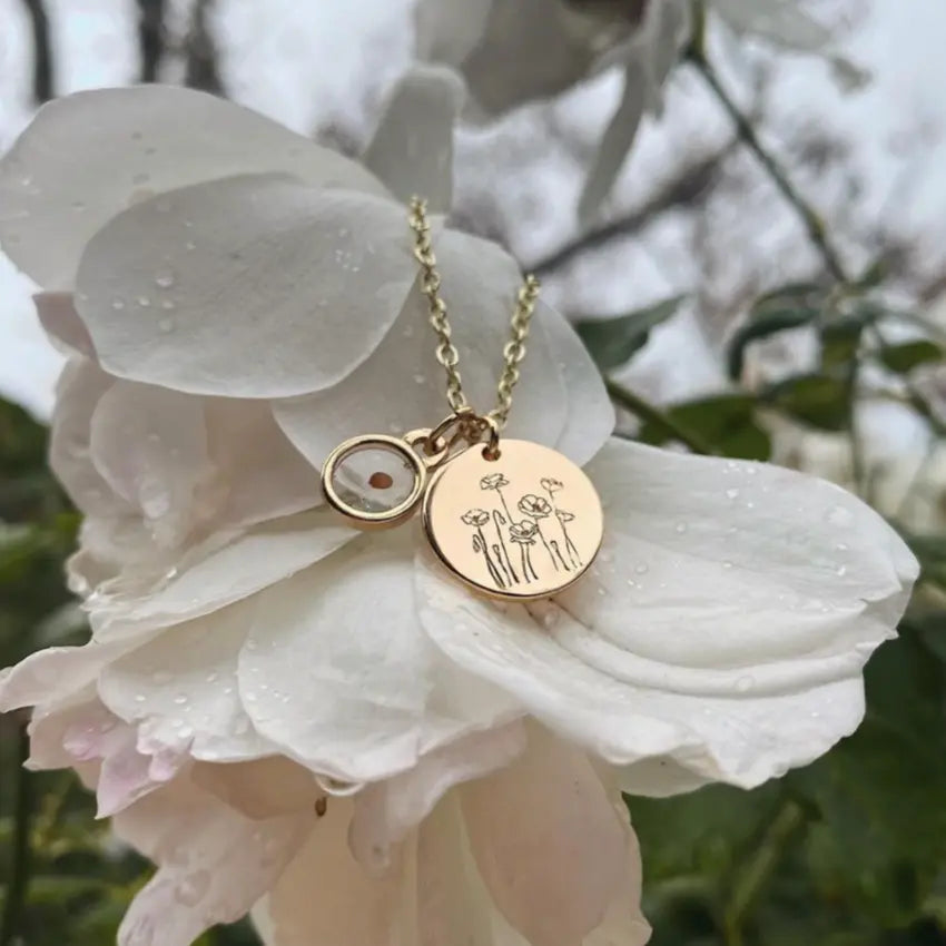 Gold necklace with circular pendants on a white flower