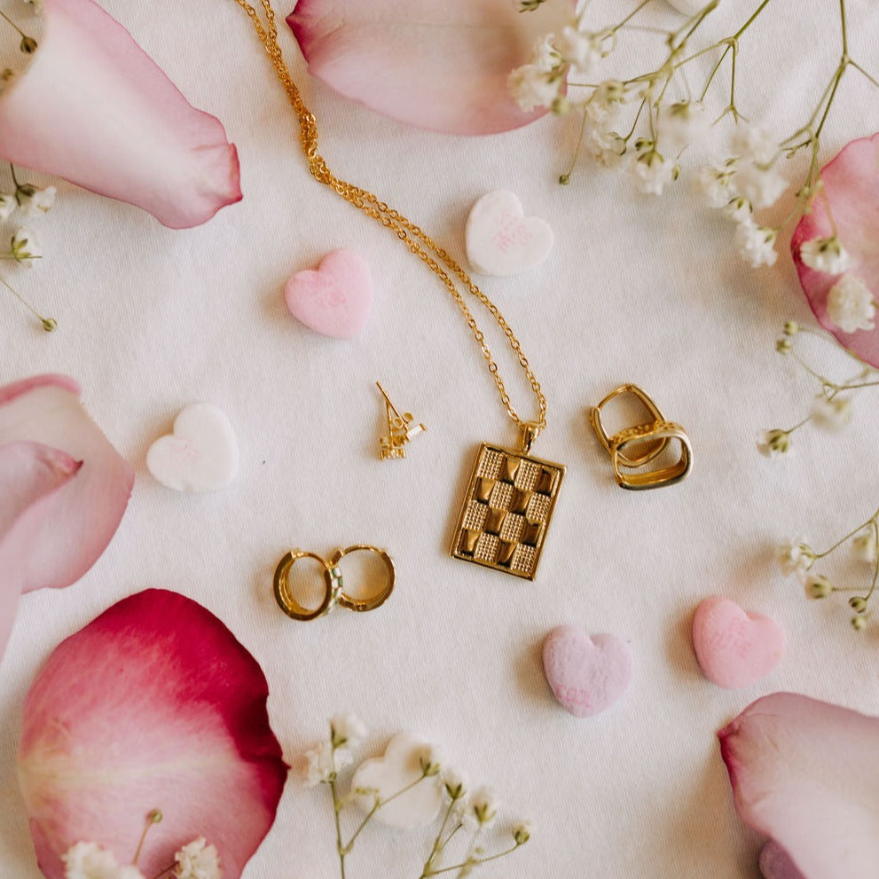 Checkered Necklace in Gold, a gold filled rectangle pendant necklace, in a flat lay with huggie hoops and studs.